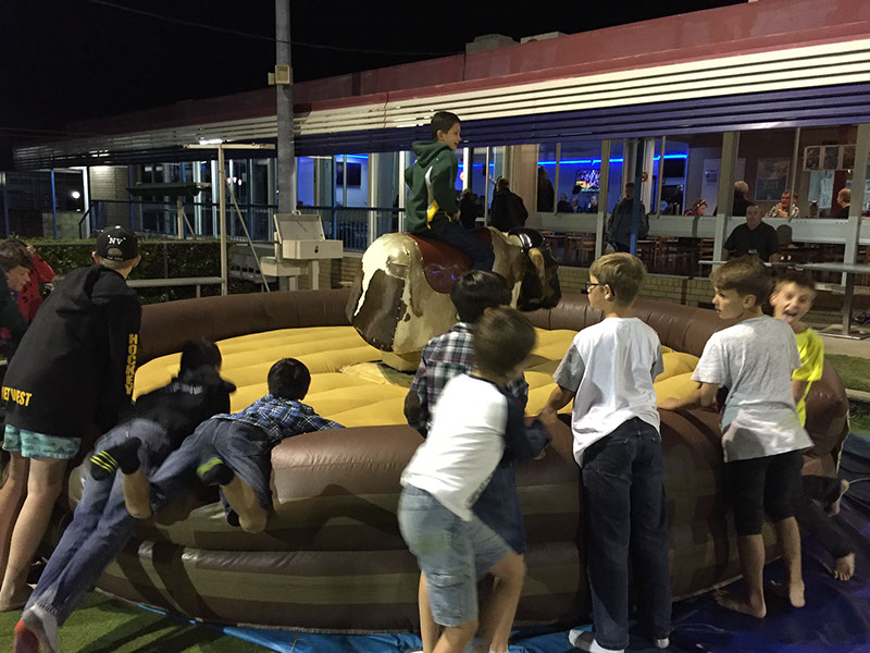 Kids riding the mechanical bull at a club event